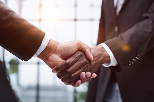 young businessmen shaking hands in the office close-up