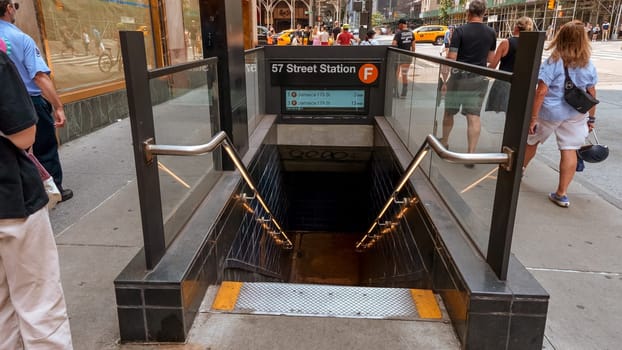 Entrance and stairs down to Wall Street subway station in New York, USA. New York City Subway is one of the world's oldest public transit systems. New York, USA - July 15, 2023.
