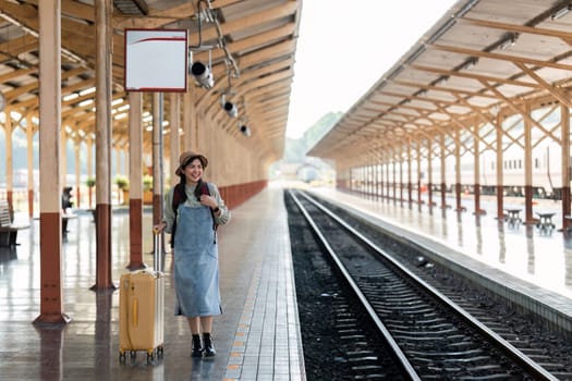 Woman traveler tourist walking with luggage at train station. Active and travel lifestyle concept.