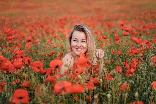 Happy woman in a red dress in a beautiful large poppy field. Blond sits in a red dress, posing on a large field of red poppies.