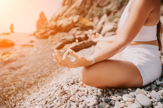 Woman sea yoga. Back view of free calm happy satisfied woman with long hair standing on top rock with yoga position against of sky by the sea. Healthy lifestyle outdoors in nature, fitness concept.