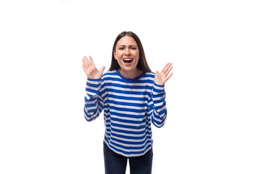 young groovy cheerful caucasian woman with dark hair dressed in a blue striped sweatshirt on a white background.