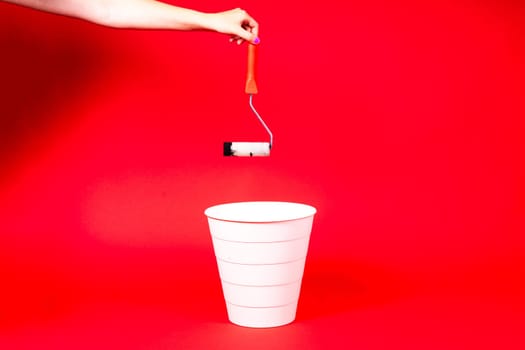 Construction roller is thrown into the trash on red background