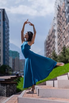 Beautiful Asian ballerina dancing outdoors. Urban landscape