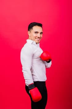 Businessman standing with boxing gloves over a red background. Looking at camera