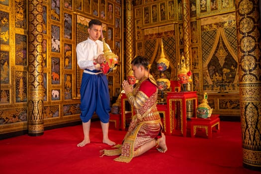 Wide shot of Asian man with Thai style cloth hold Khon mask and stand with action for traditional ceremony of respect to teacher.