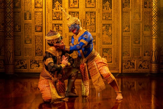 Khon or traditional Thai classic masked from the Ramakien with black and blue monkey stand together with action of traditional dance with Thai paintings background.