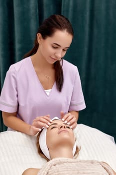 Beautiful woman getting face massage treatment in beauty salon. Skin care.