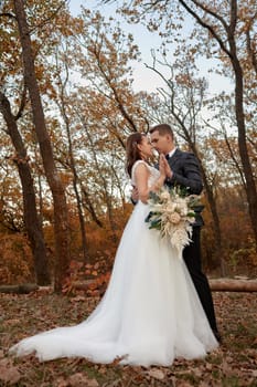 Newly married couple standing in countryside in fall