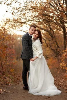 Newly married couple standing outdoor on natural background