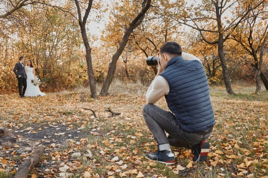 Professional wedding photographer taking pictures of the bride and groom outdoor