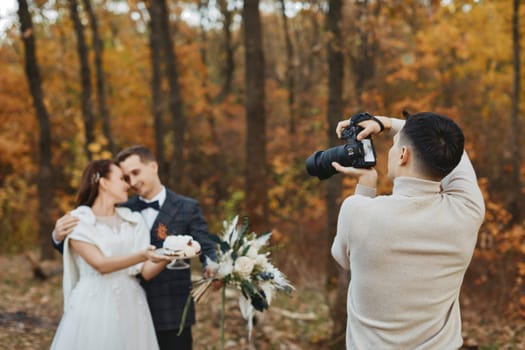 wedding photographer taking pictures of the bride and groom on the wedding day in autumn