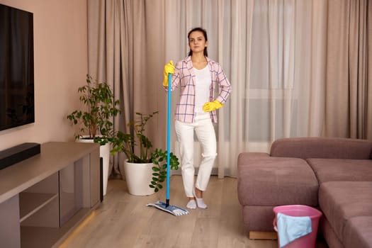 young woman cleaning and mopping floor at living room at the evening, daily housekeeping