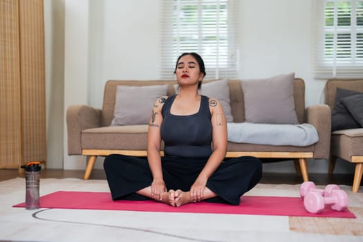 Asian overweight woman doing stretching exercise at home on fitness, Stretching training workout on yoga mat at home for good health and body shape.