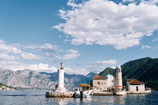 Boats are moored near the small island of Gospa od Skrpjela in the Bay of Kotor. Montenegro. High quality photo