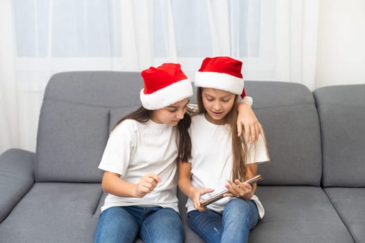 New year concept. christmas, x-mas, winter, happiness concept - two adorable cute girls playing with tablet pc. High quality photo