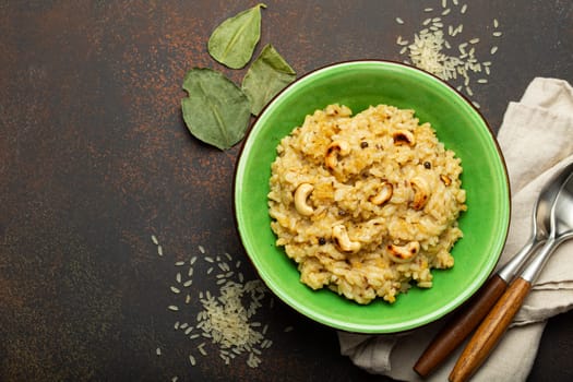 Ven Pongal (Khara Pongal), traditional Indian savoury rice dish made during celebrating Pongal festival, served in bowl top view on concrete rustic background.