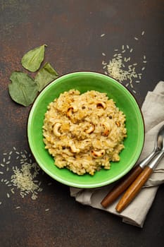 Ven Pongal (Khara Pongal), traditional Indian savoury rice dish made during celebrating Pongal festival, served in bowl top view on concrete rustic background.