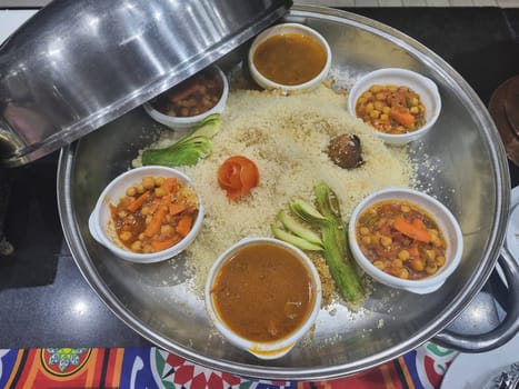 Various vegetables and meat with curry sauce in a frying pan along with rice on the table in a restaurant. View from above.