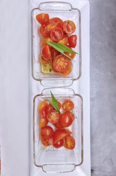 Delicious appetizer of cherry tomatoes in glass plates on a white background