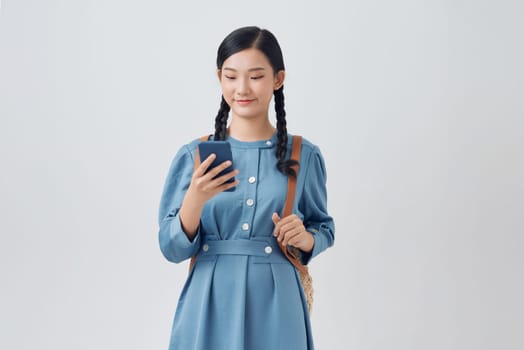  Smiling woman in denim dress using mobile phone