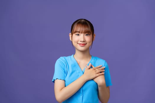 Happy nice charming woman hold hands heart honest smile isolated on purple color background