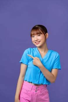 attractive cheerful girl demonstrating copy space ad new isolated over purple background