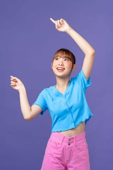 Asian beautiful young woman pointing both hands with finger on upper side with smile face. 