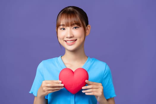 Asian woman with red heart on purple background