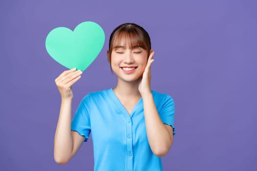 Young good mood beautiful stunning cute girl hold paper heart valentine day isolated on purple