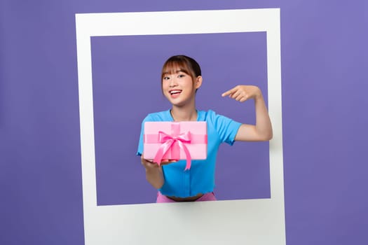 Photo of charming excited lady hold present box looking inside photo frame empty space on color background