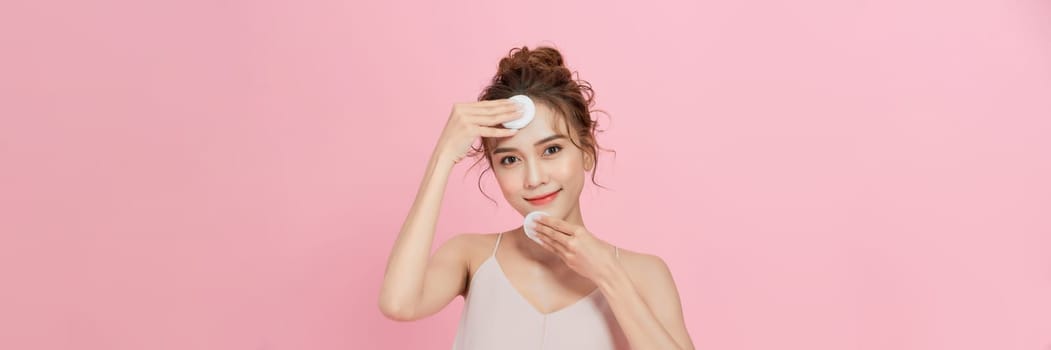  attractive asian young woman applying facial wipe on her face remover makeup, essence or lotion of skin care.