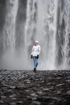 Alone woman with raincoat in Skogafoss, Iceland