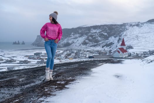 Woman in pink sweater and beanie in Vik, Iceland