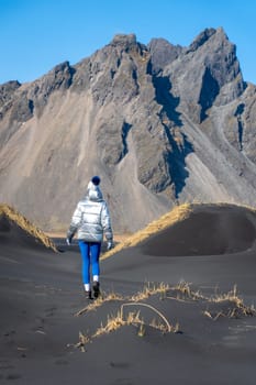 Rear view of a woman walking in the dunes of Stokksnes, Iceland