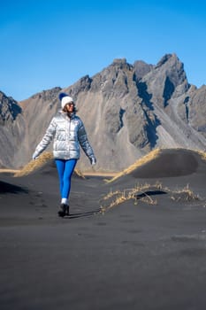 Woman walking in the dunes of Stokksnes, Iceland