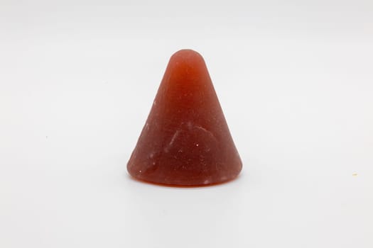 A closeup of cuberdon, a cone-shaped Belgian candy on a white background