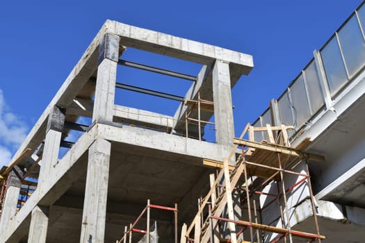 monolithic building under construction with wooden scaffolding