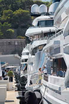 Monaco, Monte Carlo, 28 September 2022 - Invited wealthy clients inspect megayachts at the largest fair exhibition in the world yacht show MYS, port Hercules, yacht brokers, sunny weather. High quality photo