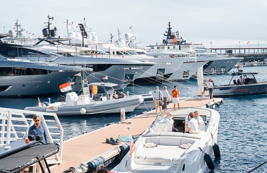 Monaco, Monte Carlo, 29 September 2022 - a boat with guests of yacht brokers departs from the shore in the largest fair exhibition in the world yacht show MYS, port Hercules, rich clients, sunny. High quality photo