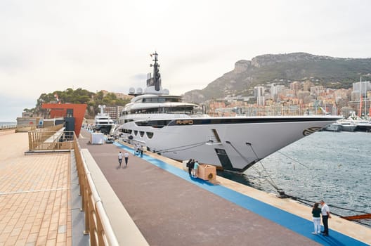 Monaco, Monte Carlo, 29 September 2022 - Invited wealthy clients inspect mega yachts at the largest fair exhibition in the world yacht show MYS, port Hercules, yacht brokers, sunny weather. High quality photo