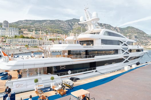 Monaco, Monte Carlo, 29 September 2022 - Invited wealthy clients inspect mega yachts at the largest fair exhibition in the world yacht show MYS, port Hercules, yacht brokers, sunny weather. High quality photo