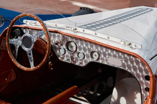 vintage open-top car at the yacht show in Monaco on a sunny day, leather seats, spoked wheels, close-up. High quality photo