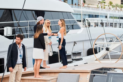 Monaco, Monte Carlo, 29 September 2022 - Invited wealthy clients inspect mega yachts at the largest fair exhibition in the world yacht show MYS, port Hercules, yacht brokers, sunny weather. High quality photo