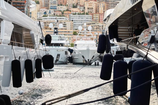 Sun glare on glossy board of mega yacht, anchor, tranquillity in port Hercules, bow of moored huge boat at sunny day, Monaco, Monte-Carlo. High quality photo