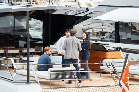 Monaco, Monte Carlo, 29 September 2022 - Invited wealthy clients inspect mega yachts at the largest fair exhibition in the world yacht show MYS, port Hercules, yacht brokers, sunny weather. High quality photo