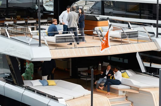 Monaco, Monte Carlo, 29 September 2022 - Invited wealthy clients inspect mega yachts at the largest fair exhibition in the world yacht show MYS, port Hercules, yacht brokers, sunny weather. High quality photo