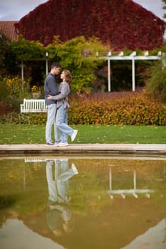 lovely young couple kissing outdoors in autumn. Loving couple walking in nature. Autumn mood. Happy man and woman hugging and kissing in autumn. Love. Fashionable couple outdoors. Fashion, people and lifestyle. Stylish couple in autumn outfit.