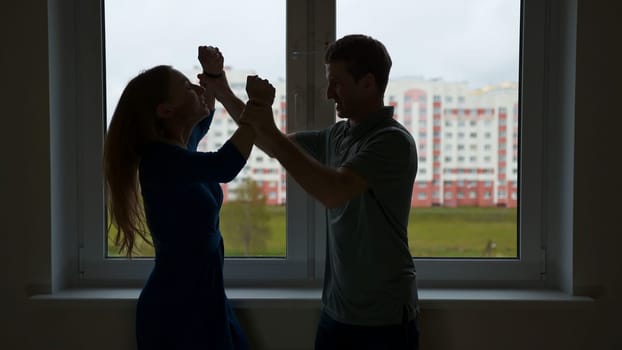 The silhouette of the young spouses swearing and fighting, but then reconciliation