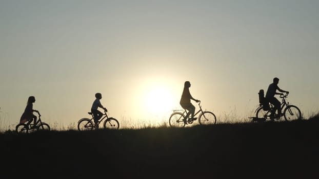 A friendly large family with bicycles at sunset